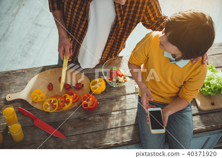 Dad giving instructions to his son while preparing food Dad giving instructions to his son while preparing food 40371920