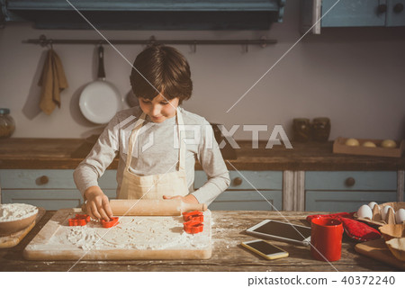 Little boy enjoying cooking of biscuits 40372240