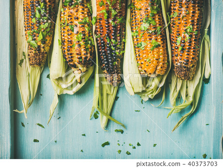 Grilled sweet corn with pesto sauce and herb, copy space Grilled sweet corn with pesto sauce and herb, copy space 40373703
