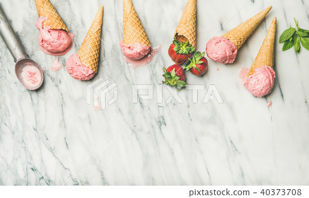 Flat-lay of homemade yogurt strawberry ice cream in waffle cones Flat-lay of homemade yogurt strawberry ice cream in waffle cones 40373708