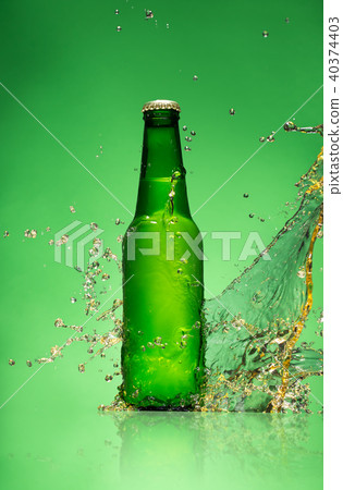 Bottle of beer with splash, on green background Bottle of beer with splash, on green background 40374403