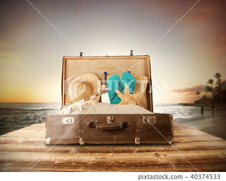 Travel concept with old suitcase on wooden planks Travel concept with old suitcase on wooden planks 40374533