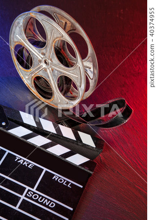 Cinema clapboard and reel on black stone Cinema clapboard and reel on black stone 40374955