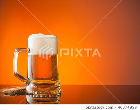 Glass of beer with orange background Glass of beer with orange background 40374959