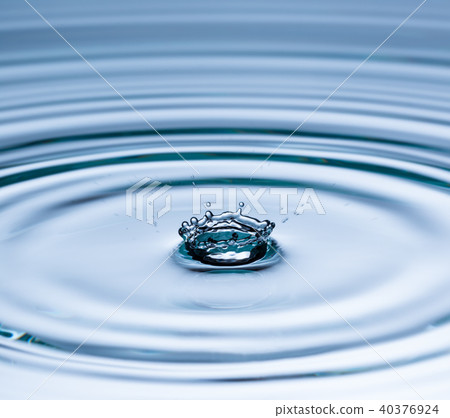 Drop of water falling into water surface 40376924