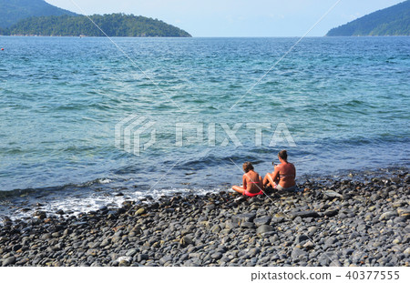 tourists sit on the beautiful rocky beach 40377555