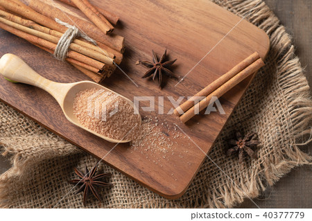 brown sugar on wood scoop and cinnamon sticks 40377779