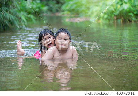 brother and sister playing in river on summer 40378011