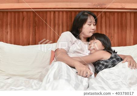 mother and her daughter hugging while sleeping 40378017