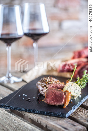 Two cups with red wine roasted and raw beef steak. Two cups with red wine roasted and raw beef steak. 40379526