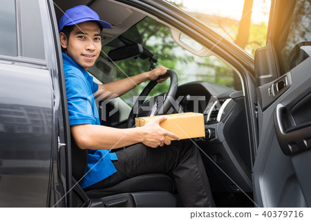 Delivery messenger man with cardboard box outside the warehouse Delivery messenger man with cardboard box outside the warehouse 40379716