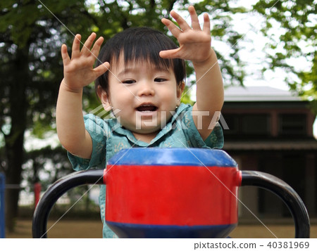 A 1 year old boy who plays with park play equipment 40381969