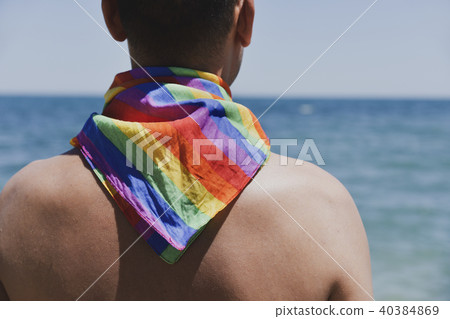 man with a rainbow flag in front of the ocean man with a rainbow flag in front of the ocean 40384869