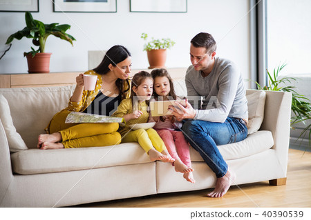 Young family with two children and tablet preparing for holidays. Young family with two children and tablet preparing for holidays. 40390539