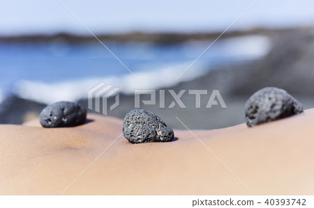 stones on the back of a man on the beach stones on the back of a man on the beach 40393742