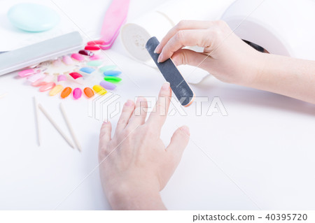 Woman doing manicure with black file on table Woman doing manicure with black file on table 40395720