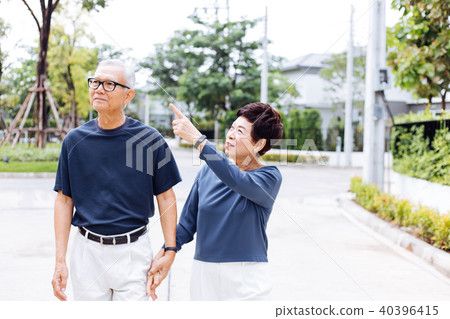 Senior Asian couple walking in the park Senior Asian couple walking in the park 40396415