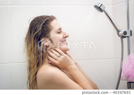 Toned closeup portrait of sexy young woman relaxing under shower Toned closeup portrait of sexy young woman relaxing under shower 40397691