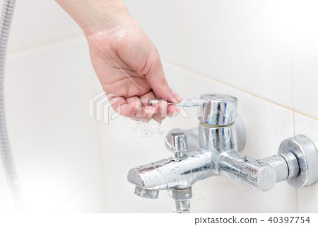 Closeup image of female hands opens water tap in bathroom Closeup image of female hands opens water tap in bathroom 40397754