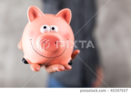 Man holding a piggy bank 40397937