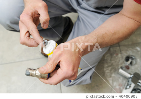 Plumber putting a paste sealant. 40400905