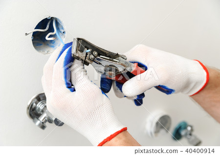 Electrican stripping insulation from wire. 40400914