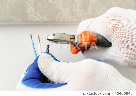 Electrican shortens electric wire. 40400943