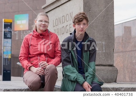 Young couple is sitting under stone pedestal Young couple is sitting under stone pedestal 40401738