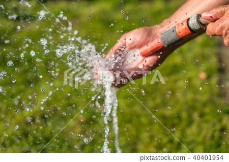 watering garden ,  holding water hose washing hand 40401954