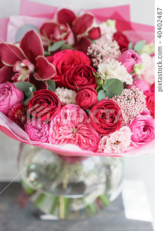 Bright red bouquet of beautiful flowers on wooden table. Floristry concept. Spring colors. the work Bright red bouquet of beautiful flowers on wooden table. Floristry concept. Spring colors. the work 40402487