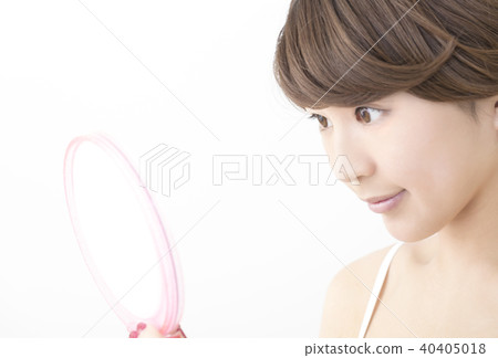 A woman looking at a mirror 40405018