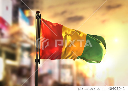 Guinea Flag Against City Blurred Background Guinea Flag Against City Blurred Background 40405941