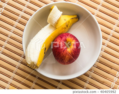 White bowl containing banana and apple. White bowl containing banana and apple. 40405992