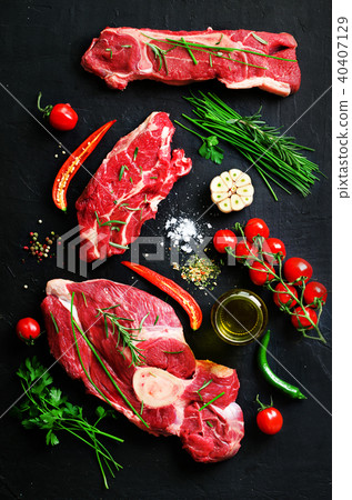 Raw meat steaks with cherry tomatoes, hot pepper 40407129