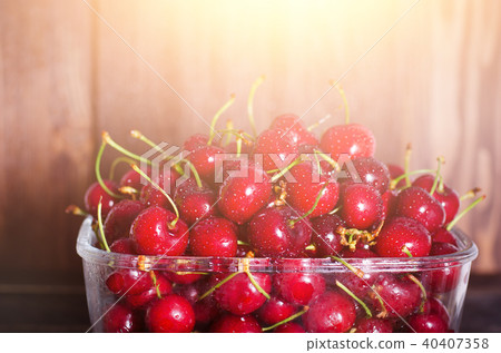 Sweet red cherries in glass bowl on dark wooden 40407358