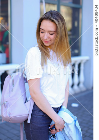 Nice girl standing near window with smartphone and glasses on table. Nice girl standing near window with smartphone and glasses on table. 40409434