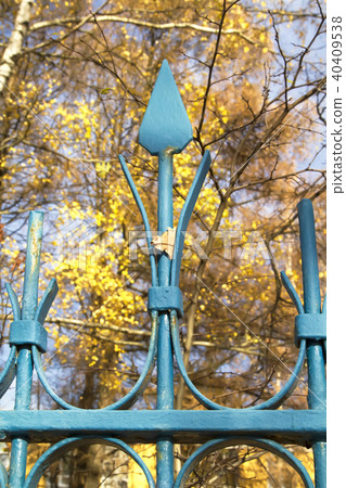 Blue metal fence with a single leaf Blue metal fence with a single leaf 40409538