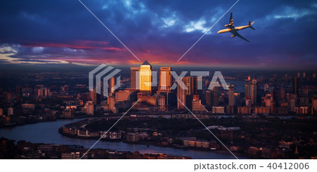 Passengers airplane flying above London city in the sunset light 40412006