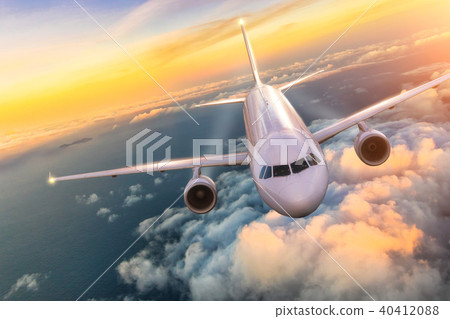 Airplane jetliner flying above clouds in beautiful sunset 40412088