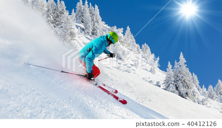 Skier on piste running downhill 40412126