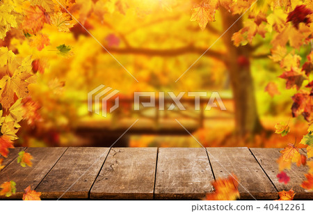 Autumn background with falling leaves and empty wooden table Autumn background with falling leaves and empty wooden table 40412261