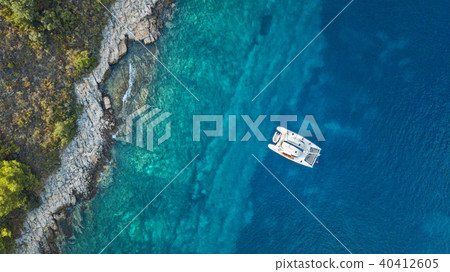 Aerial view of anchoring catamaran next to island. Aerial view of anchoring catamaran next to island. 40412605
