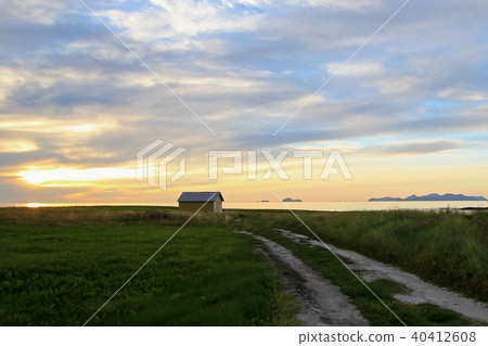 Beautiful yellow house at the coast of Lofoten Islands with view to the Vesteralen Islands at sunset 40412608