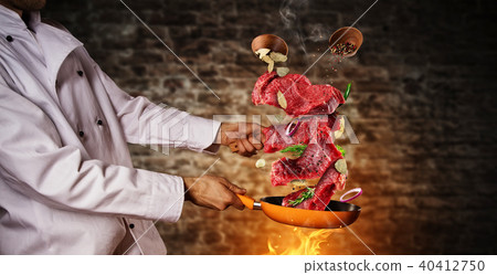Closeup of chef preparing steaks meat on grill pan Closeup of chef preparing steaks meat on grill pan 40412750
