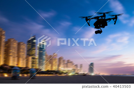 Drone silhouette flying above Dubaicity panorama Drone silhouette flying above Dubaicity panorama 40413503