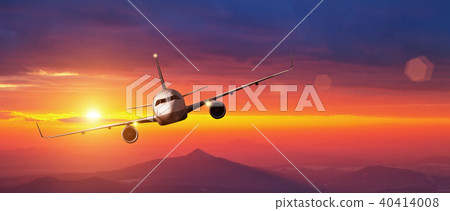 Commercial airplane flying above mountains in sunset 40414008