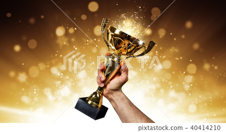 Man holding up a gold trophy cup 40414210