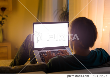 Man working on laptop in cozy home interior Man working on laptop in cozy home interior 40414524