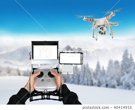 Man hands handling drone in winter landscape 40414918
