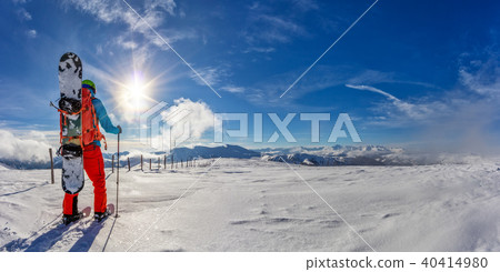 Snowboarder walking on snowshoes in powder snow. 40414980